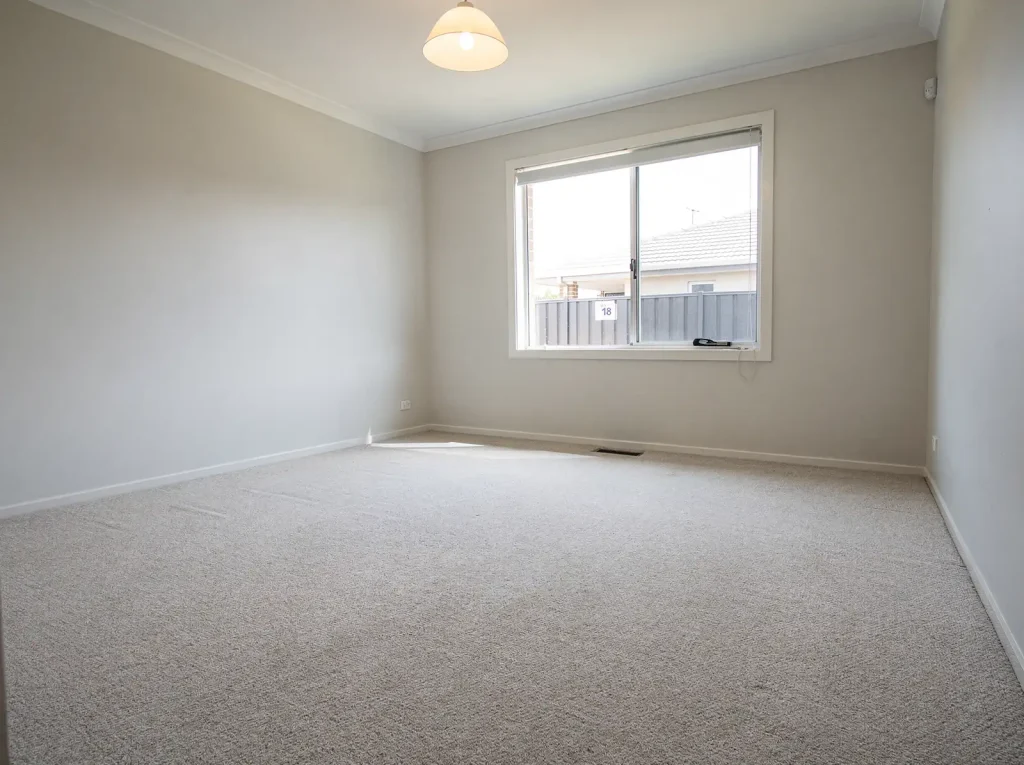 Freshly cleaned carpet in a bright empty Rockingham rental room.